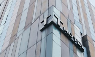 외벽 모서리의 입체 TRIA HOTEL 간판(올려다본 모습)